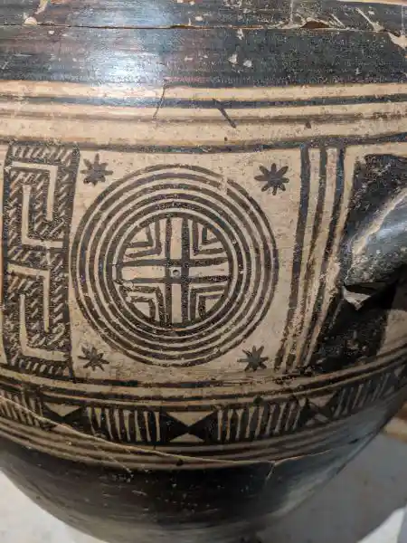 Close-up of encircled cross motif on ancient Greek funerary amphora from Geometric period